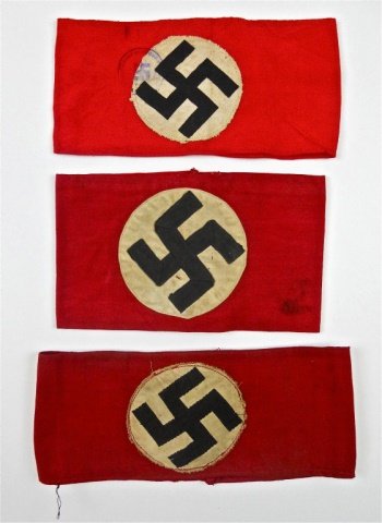 WWII German NDSAP Armbands: Three armbands of cotton construction with white medallion and canted swastika. One having sewn two-piece swastika. One beVo woven insignia. One with printed insignia with stamp in ink. Light soiling.
