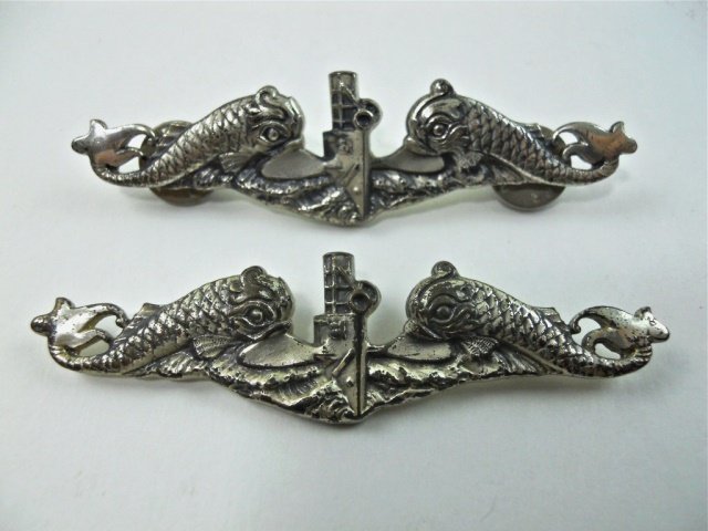 Two WWII Sterling Silver U.S.N Submarine Pins, LGB: Die struck sterling silver pin depicts oncoming sub flanked by dolphins. Reverse marked "LGB Sterling." One badge missing pin.
