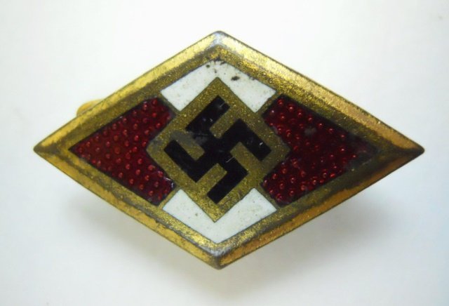 WWII German HJ Gold Honor Pin: Die struck alloy badge with enamel and gold wash depicts central canted swastika with red and white enamel in diamond shaped gold frame. Reverse with soldered wire safety pin closure. Faint "RZM" stam