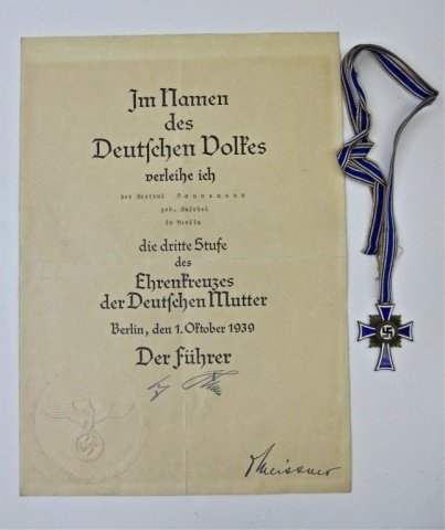 WWII German Mother's Cross with Award Document: Die struck alloy construction with enamel and bronze finish depicts swastika in center with "DER DEUTSCHES MUTTER" in border over blue and white enamel cross. Reverse dated, "16 December 1938 " with A