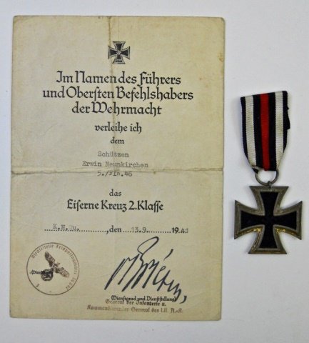WWII German Iron Cross Second Klasse with Document: Three piece die struck iron and alloy construction. Center canted swastika with 1939 date. Reverse carries 1813 date and suspension ring stamped 23 with red, white and black ribbed rayon ribbon. Accom