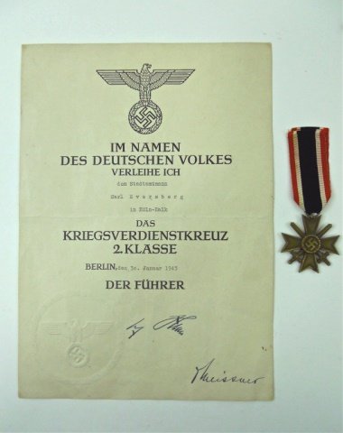 WWII War Merit Cross, Second Klasse with Document: Die struck alloy construction with with bronze finish depicts wreathed canted swastika at center over cross with crossed swords and red, white blacked ribbed rayon ribbon. Accompanied by paper documen
