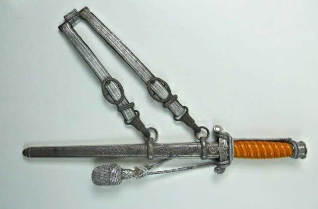 WWII Army Dress Dagger - Anton Winger Jr.: Silver washed fittings with orange Bakelite grip. Cross guard with spread winged eagle clutching canted wreathed swastika. Pommel and ferule with oak leaf decoration. Blade etched on reverse, "A.W. Jr