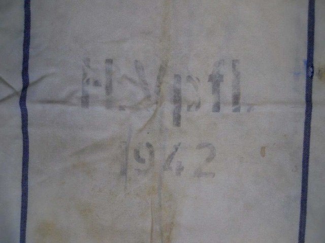 WWII German Grain Bag, H.Vpfl 1942: White cotton bag with blue vertical stripes. Stenciled in ink, "H.Vpfl 1942", reverse with spread winged eagle clutching canted wreathed swastika. 42"H x 27.5"W Wear consistent with use in field, seve