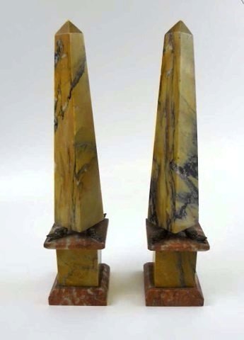 Pair of 18th C. French Marble Obelisks: Multi colored, heavily figured carved marble construction. Obelisks rest on cast brass eagle heads mounted to rose and tan marble pediments. Measure 13" H x 3"D.