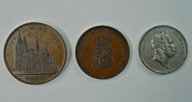 Three 19th C. European Medals, Bronze and White: One medal struck in Bronze bears view of cathedral and reads "DER DOM ZU COLN" with date 1880. Reverse with court scene and text in German. Measures 2"D. One medal struck in white metal bears profile 
