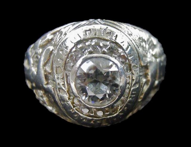 14K Gold Diamond USN Academy Class Ring, JK Averil: 14K White gold ring with inset round brilliant cut diamond, measuring 5.33mm. flanked by 14 smaller diamonds. Ring shanks with Navy and Patriotic designs. Interior engraved "J. K. A. - M. S. S. 14 MAY