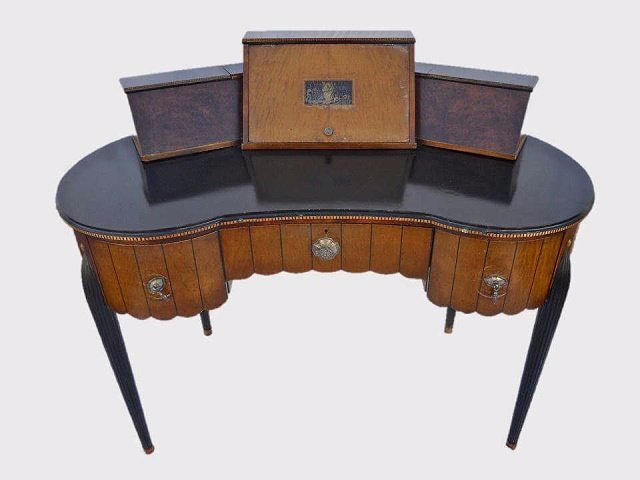Antique French Art Deco Desk, circa 1920: Circa 1920 Desk with three slotted and lidded top compartments two with burl veneer, over curved ebonized top. Three drawers with fluted front and silvered pulls. Desk supported by tapered fluted ebon