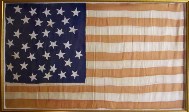 19th C. Handmade United States 35-Star Flag: One-sided flag constructed of red, white and blue wool fabric, treadle sewn with primitive hand cut stars. Preserved under glass in wood frame. A few minor areas of thread loss, fabric is faded, consi