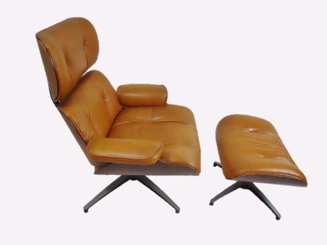 Leather Eames Style Chair and Ottoman, Selig Mfg: Leather and moulded bent wood Eames style chair and ottoman. Manufacturer label affixed to bottom "Selig Manufacturing Co., Inc. Cypress Street, Leominster, MA." Chair measures 38" H x 35" W x 28" D.