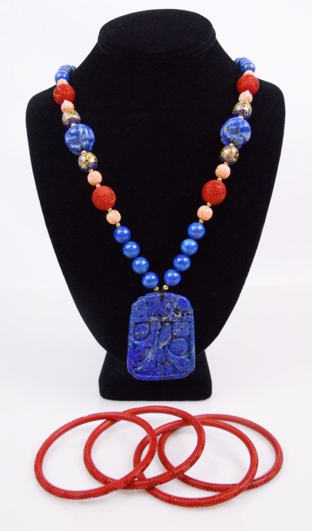 Chinese Lapis Lazuli Necklace & Cinnabar Bracelets: Vintage 2.25" carved Chinese lapis lazuli pendant with floral, bird and fruit designs carved in bas-relief suspended from a 14" L strand consisting of forty-eight round lapis lazuli beads, eight carve