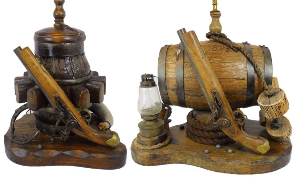 Vintage Western Themed Lamps (2): Antique wagon wheel converted to lamp with reproduction British Tower flintlock pistol and carved bone powder horn set on wood base. Measures 31" H _x000D_ _x000D_ Wooden cask stamped, "1876" with cor
