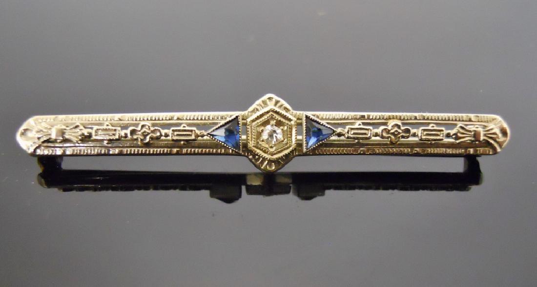 14K Gold, Diamond and Sapphire Art Deco Bar Pin: 14K white gold pin set with one center mine cut diamond flanked by two triangular cut sapphires. Pin marked 14K on clasp. Total weight 2.6 g.