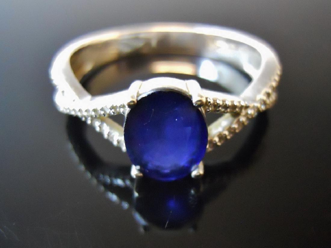 Ladies 14K Gold Diamond and Sapphire Ring: 14K white gold ring set with center oval cut sapphire flanked by twenty small round cut diamonds on either shank. Total weight 2.7 g. Ring size 7.5
