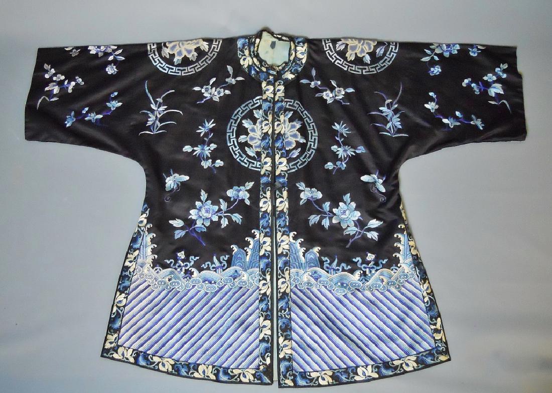 Chinese Silk Embroidered Robe, Qing Dynasty: 20th C. Chinese embroidered silk robe in graduated shades of blue and white silk thread on a black silk background. Elemental and floral imagery includes cloud patterns at bottom with thunder patterns