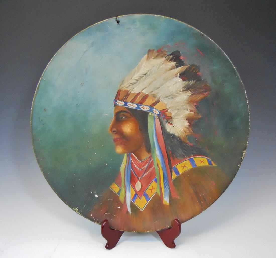 Early 20th C. Native American Painting, 1904: Antique oil painting of a Native American Chief with full headdress on concave round composite disc. Artist signature and 1904 date on reverse. Measures 20.5" in diameter. Craquelure and scattered are