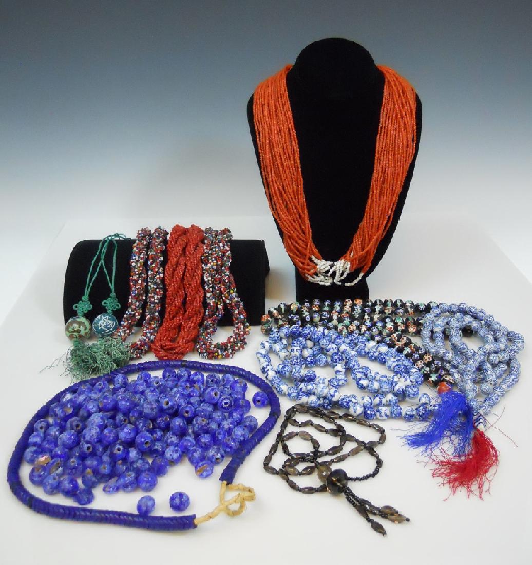 Collection of Glass, Porcelain Beaded Jewelry: Collection of jewelry and loose beads comprised of three Chinese porcelain prayer beads, two Chinese hand painted and incised porcelain pendant necklaces, a Konyak Naga glass bead necklace with coin c