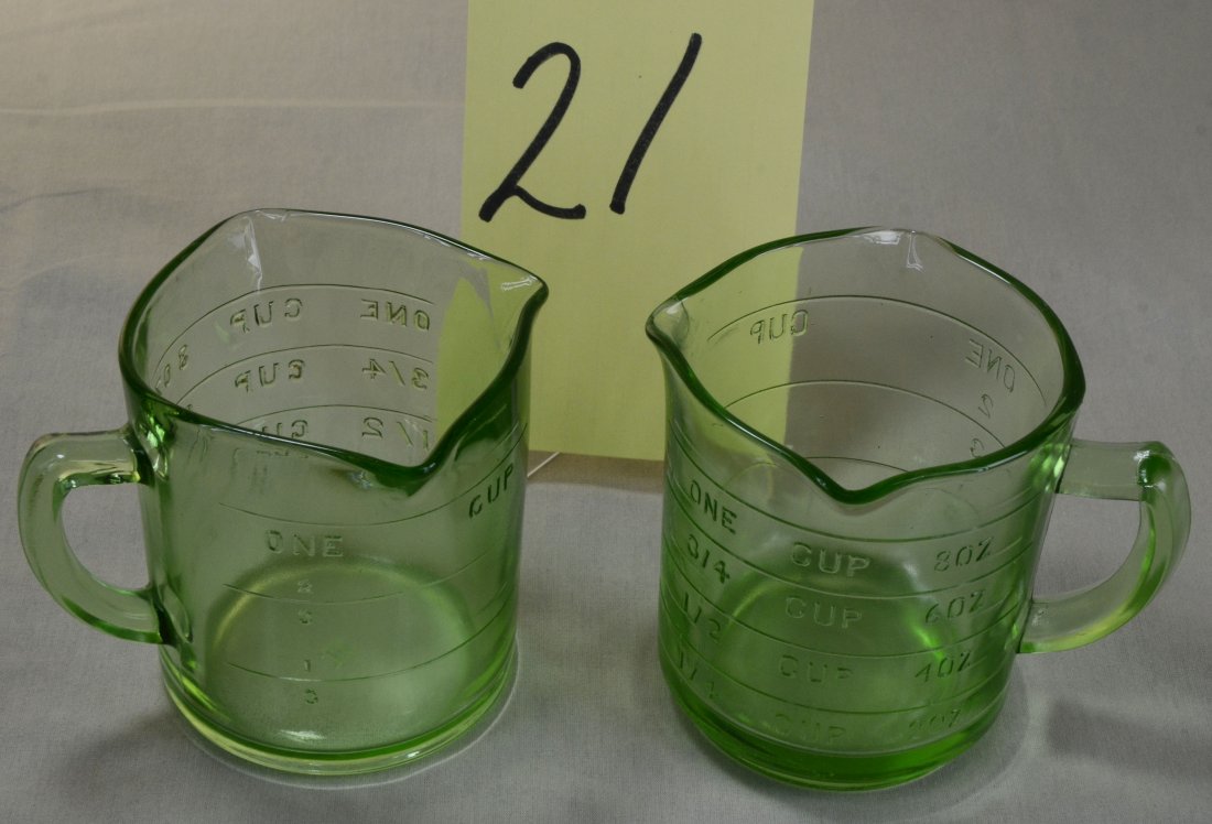 2 Green Depression Glass Measuring Cups: Two green transparent depression glass measuring cups. a) Anchor Hocking 1 cup with triple spoutsb) Unmarked one cup with triple spouts