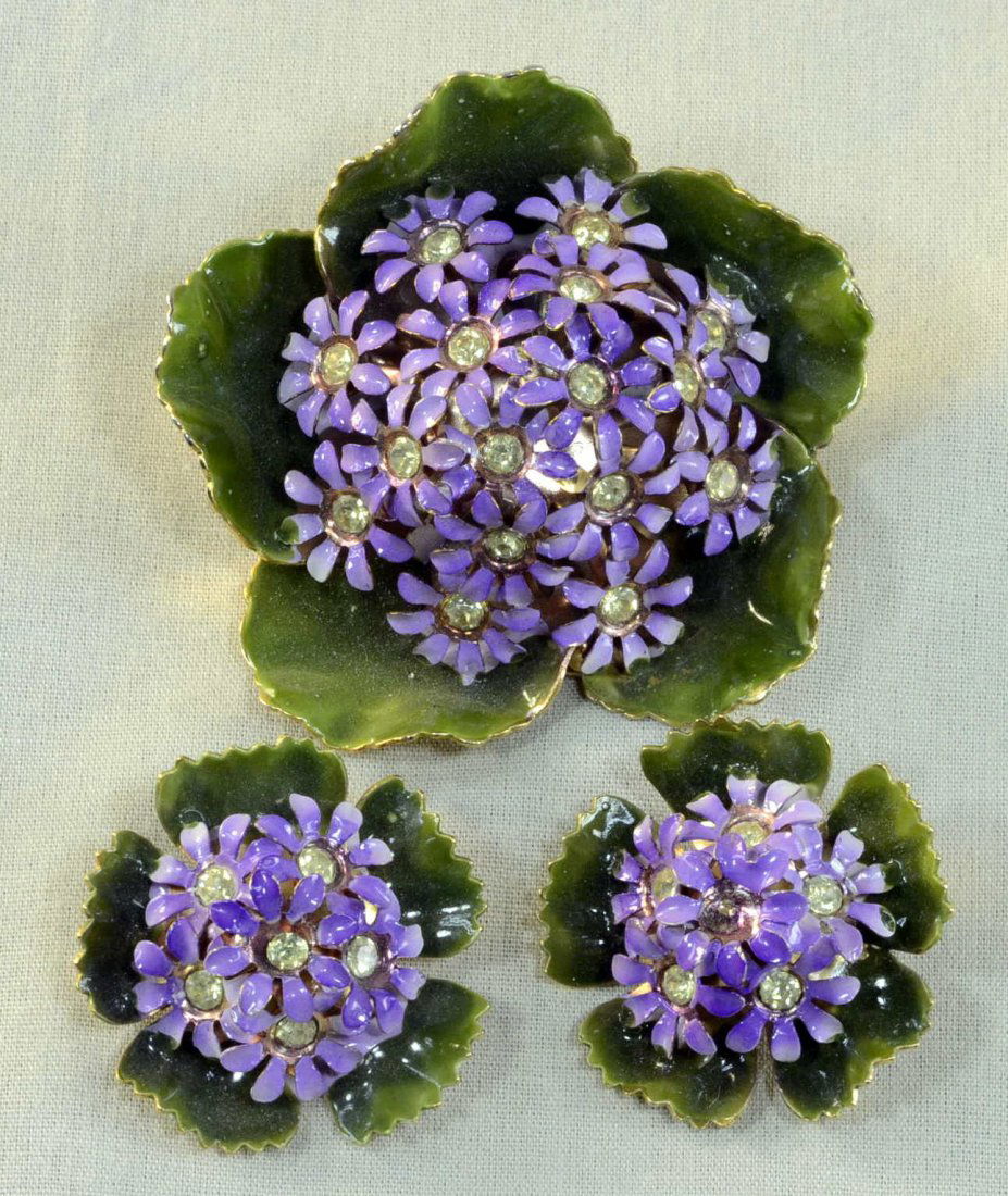 Jolle (Hess Apell) Enamel Brooch Earring Set: Jolle signed enamel brooch/pin 2.25" across - green leaves with lavender flower and clear rhinestone centers, and pair of clip on earrings approx 1.25" across.
