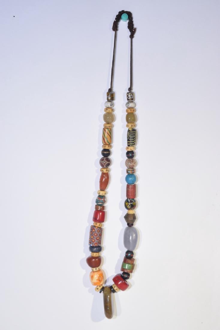 Tibetan Glass and Precious Stone Bead Necklace: Tibetan glass and precious stone bead necklace. D: 15.5in. Age wear.