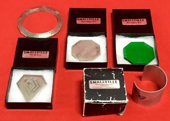 Lot of 5 Smallville replica: props Phantom Zone portal, Kryptonite Key, Kyrptonite Key, Dax-UR Beacon, Karas's Kryptonian Bracelet. Phantom Zone portal-No Box, Kara's Bracelet. Box has wear. All others in good condition