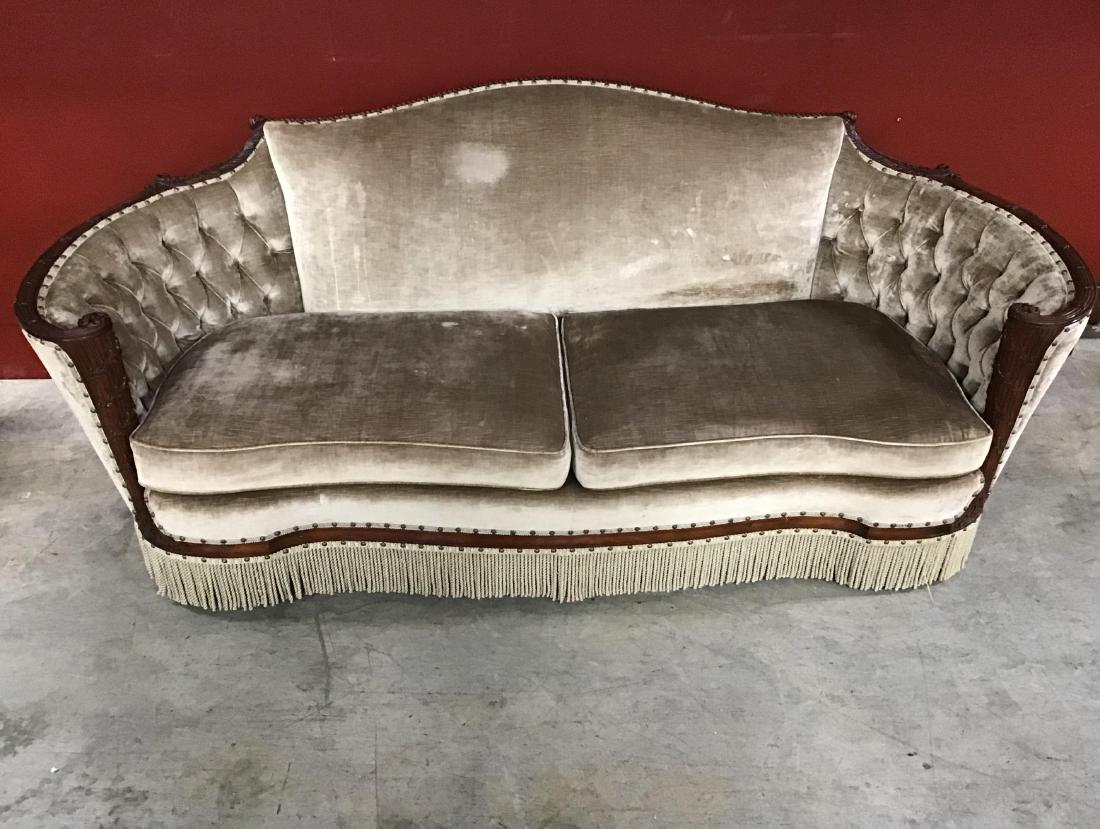 Elegant antique French Victorian Sofa: Uphostered in a champagne crushed velvet, Walnut trim, buttoned and tufted on curved arms, fringe on bottom. Walnut carved trim. This elegant sofa is in VCG for age and use.