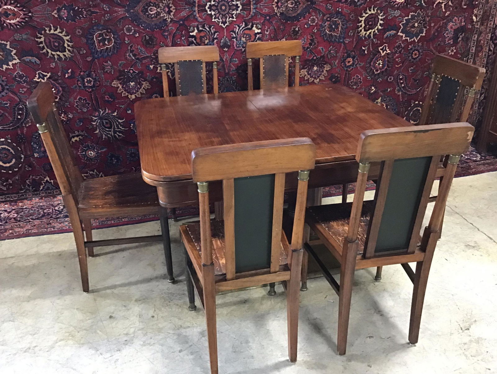 Nahogany Table and 6 Chairs: Very unusual pop up butterfly leaves on each end of table. Tbale has beautiful banded brass base with columns. Chairs embossed leather on seats and back with brass tacking. Some veneer damage, wear on
