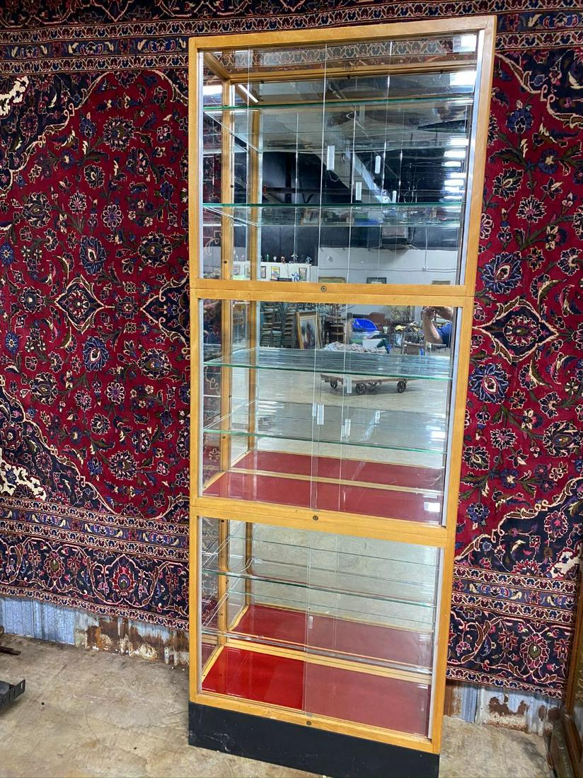 STACKING MIRRIRED BACK DISPLAY CABINET: SLIDING GLASS DOORS AND SHELVES. MAPLE FRAME, RED VELVET BOTTOMS. 97.75IN T X 36IN W X 13.75IN. HAS KEYS. MADE BY WADDEL CO., GREENFIELD, OH. OVERALL VGC- ONE GLASS SHELF IS BROKEN IN CORNER