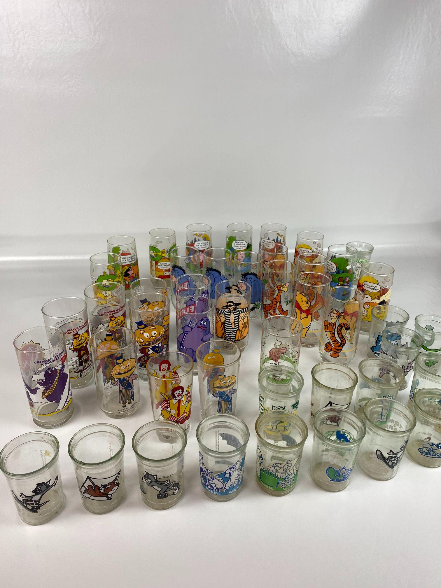 LOT OF 37 CARTOON COLLECTOR GLASSES: 13-TOM & JERRY WELCH GLASSES, 10- SNOOPY GLASSES, 8-WINNIE THE POOH GLASSES, 11-McDONALDS GLASSES, 1-LOONEY TUNES WELCH GLASS, 4-DINO WELCH GLASSES