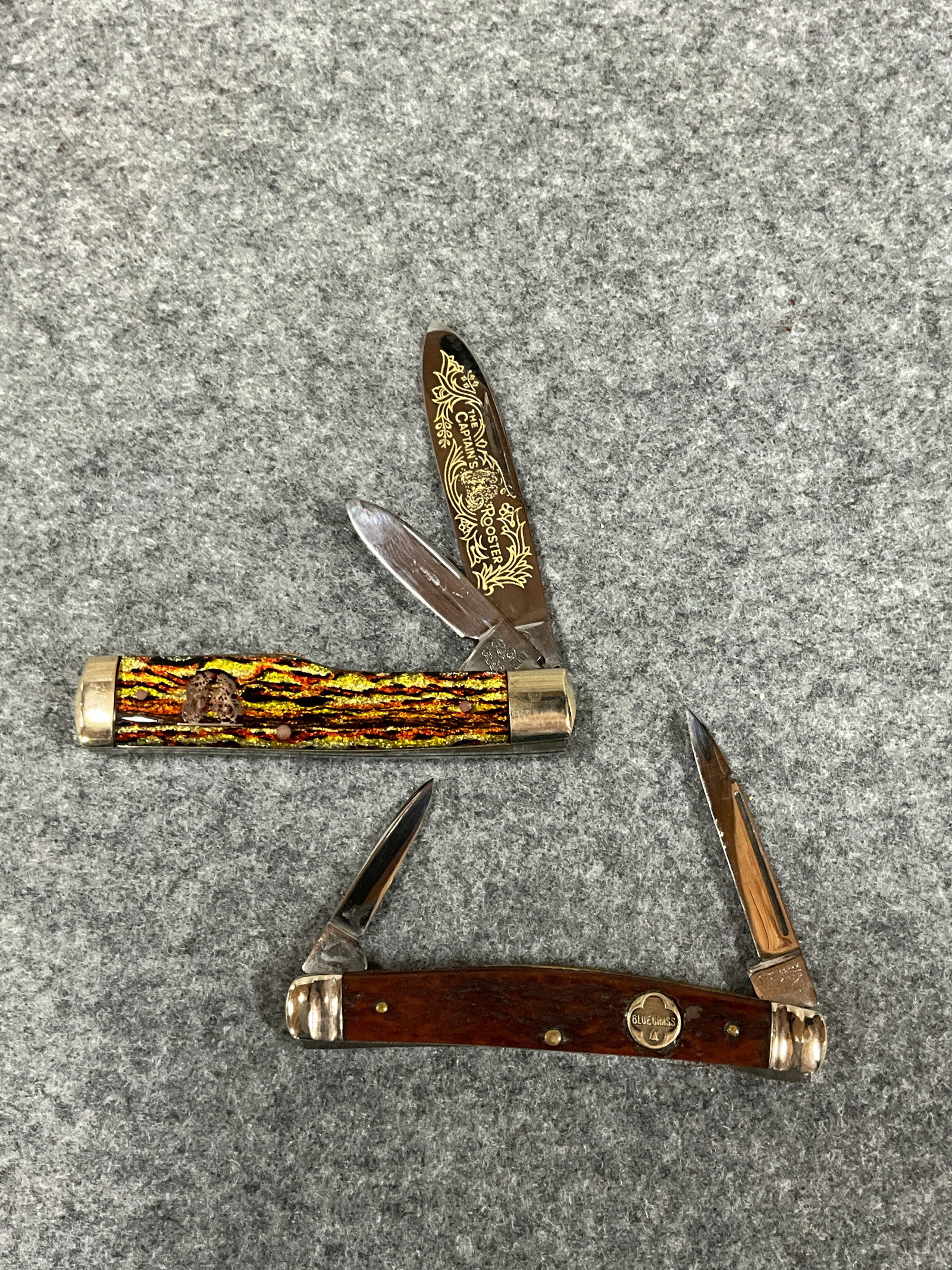 LOT OF 2 POCKET KNIVES: FRANK BUSTER CUTLERY CO. (GERMANY), THE CAPT'S. ROOSTER - GUN STOCK CHRISTMAS TREE BELKNAP NO.5228, BLUE GRASS (1981)