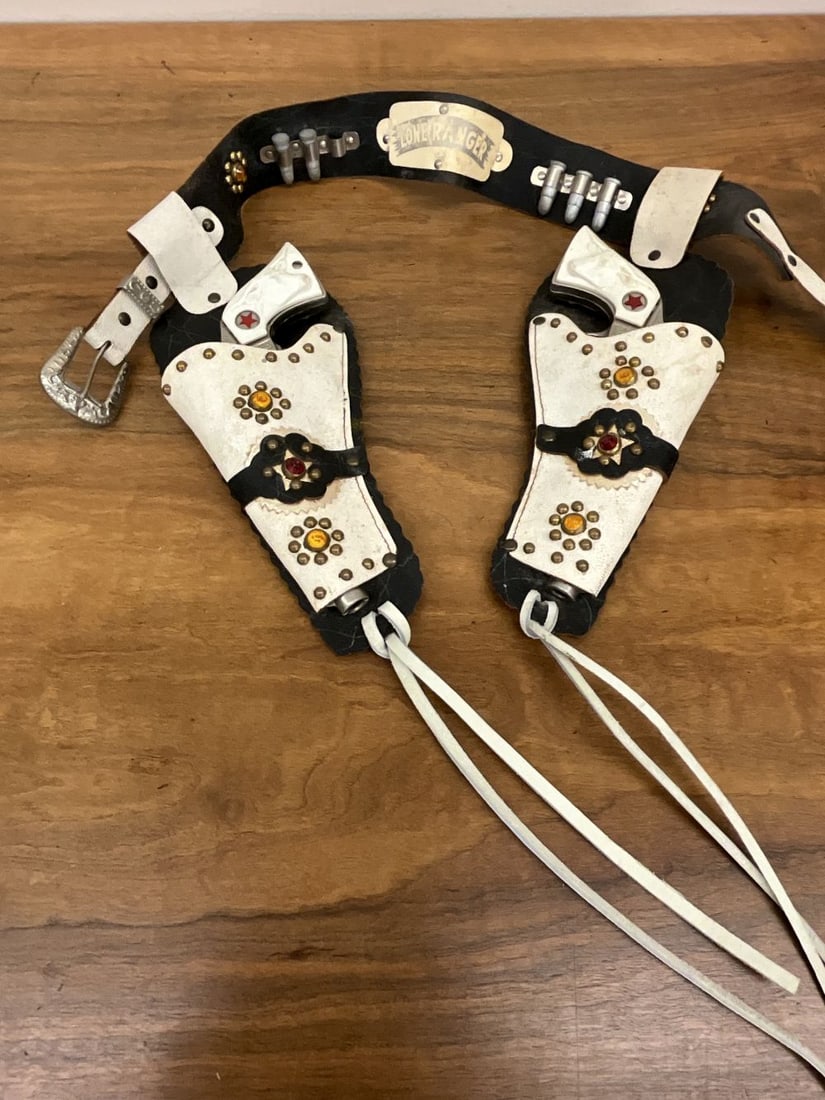 Vintage Lone Ranger Holster and Texan Jr. Cap Guns: Studded white and black holster. Trigger loose on one cap gun.