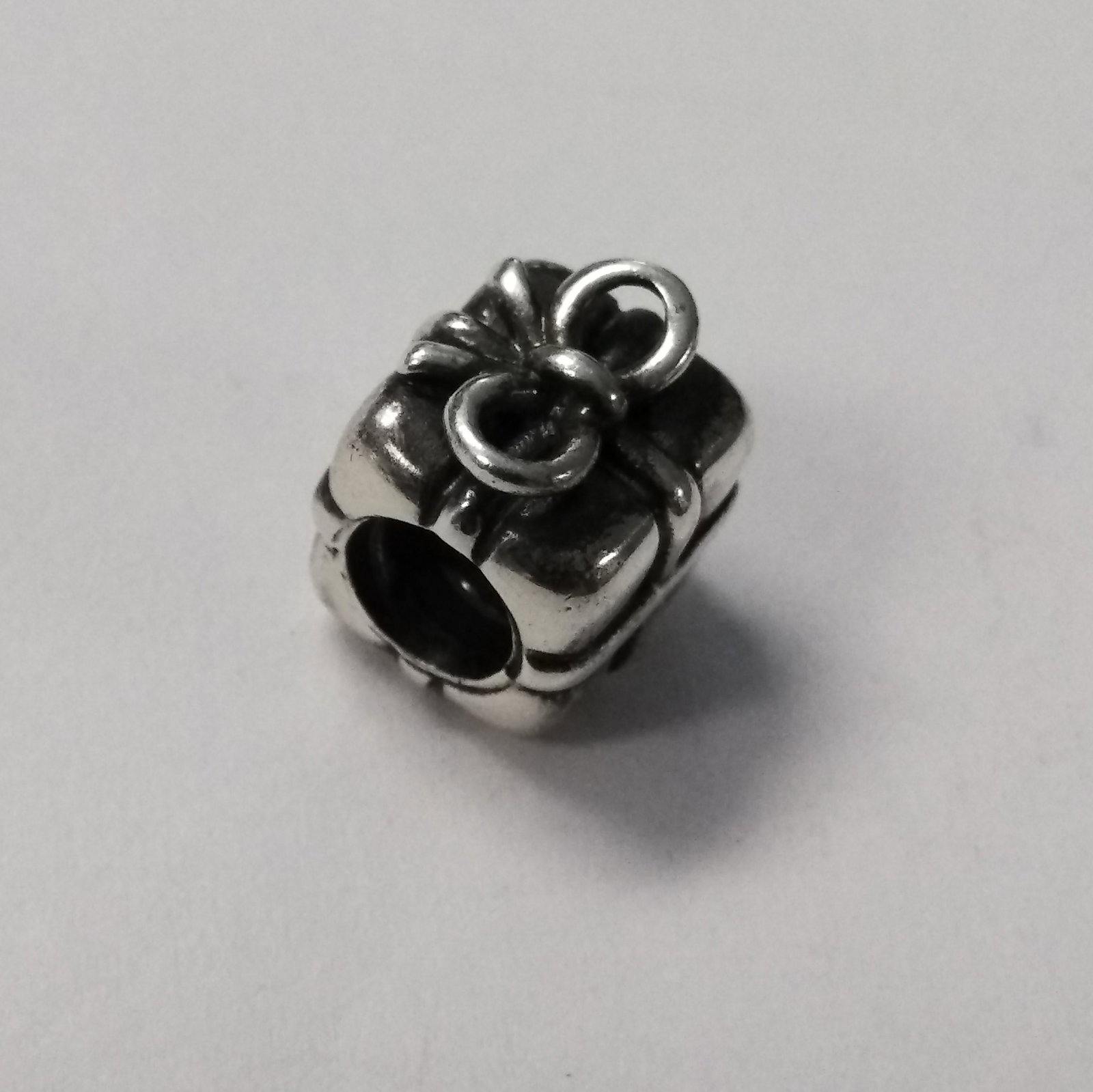 925 Silver Pandora Present with a Bow Charm .14 ozt: 925 Silver Pandora Present with a Bow Charm .14 ozt Hallmarks on the charm: 925 ALE (meaning 925 Silver, ALE is founder's father) Pre-owned jewelry may contain minor markings/imperfections throughout.