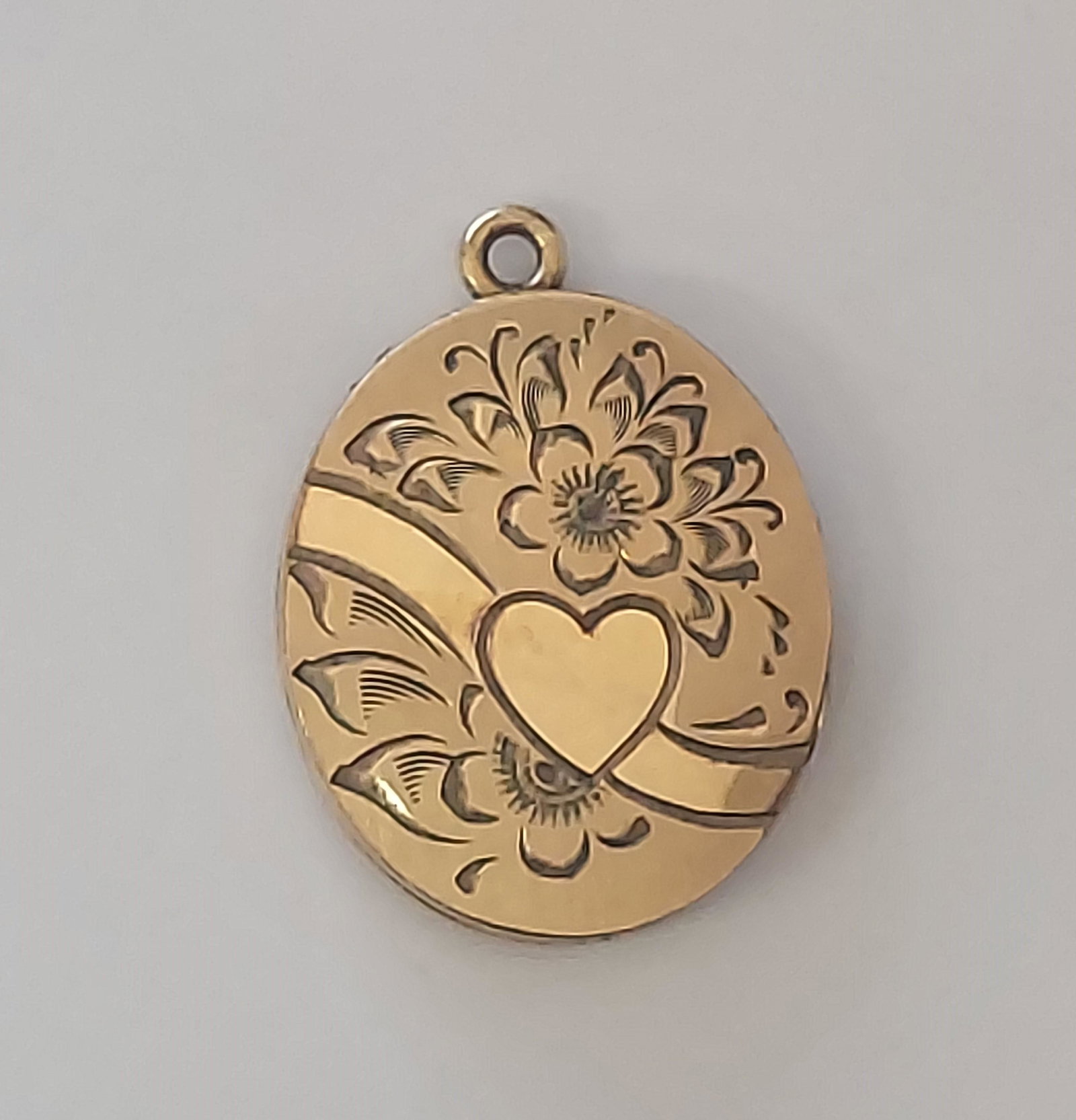 10K Yellow Gold Engraved Locket Flower & Heart Design: This is a beautiful 10k yellow gold flower and heart design engraved locket. The Locket is 1" x 3/4". It weighs 3.1 grams.