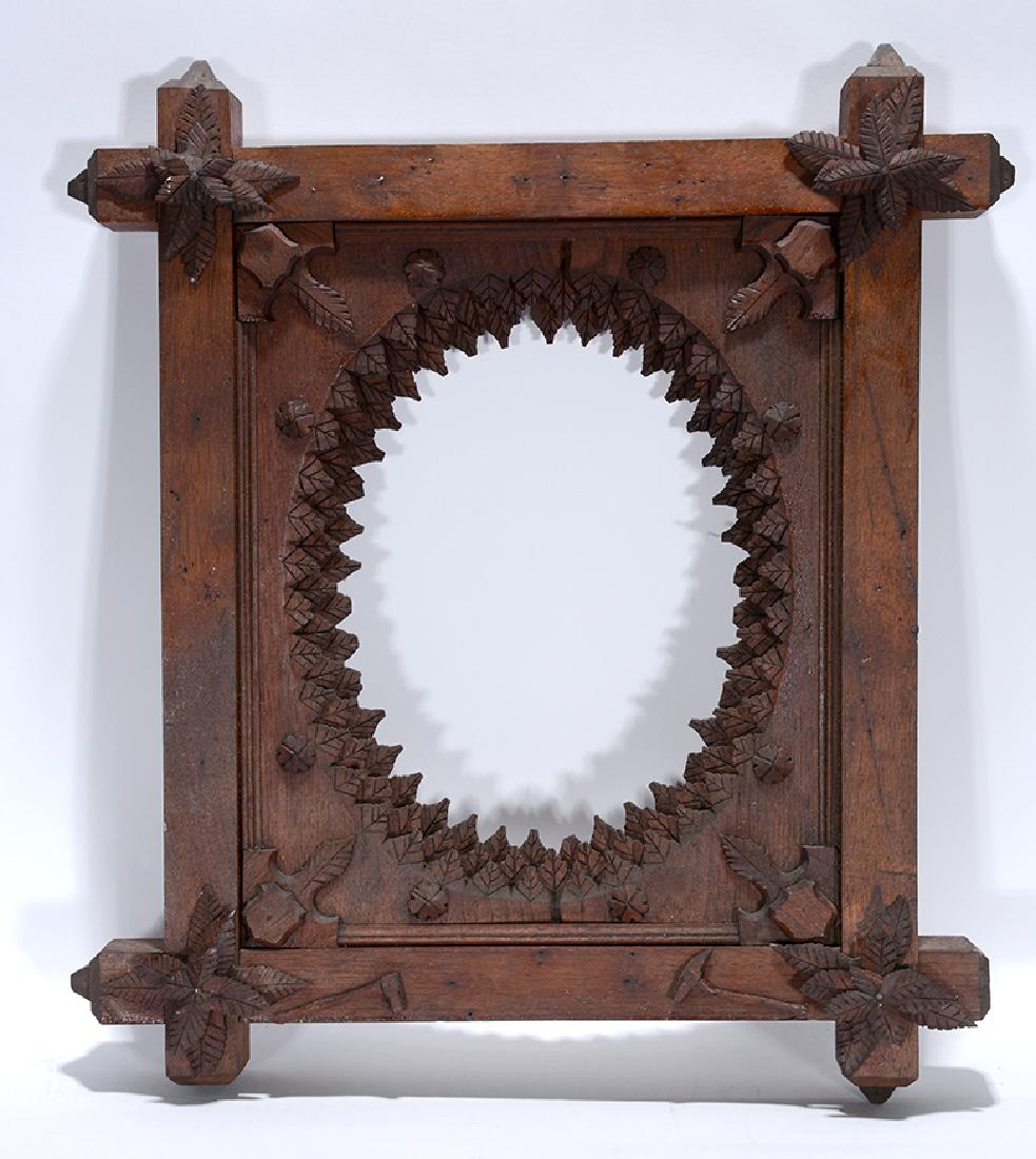 Tramp Art Pioneer Saw Tooth Picture Frame.: Tramp Art Pioneer Saw Tooth Picture Frame. Carved and stained wood with applied leaf and axe decor. Some minor loss, otherwise good condition. 18" x 20" x 1.5". Est. $300-500. Ship:$55