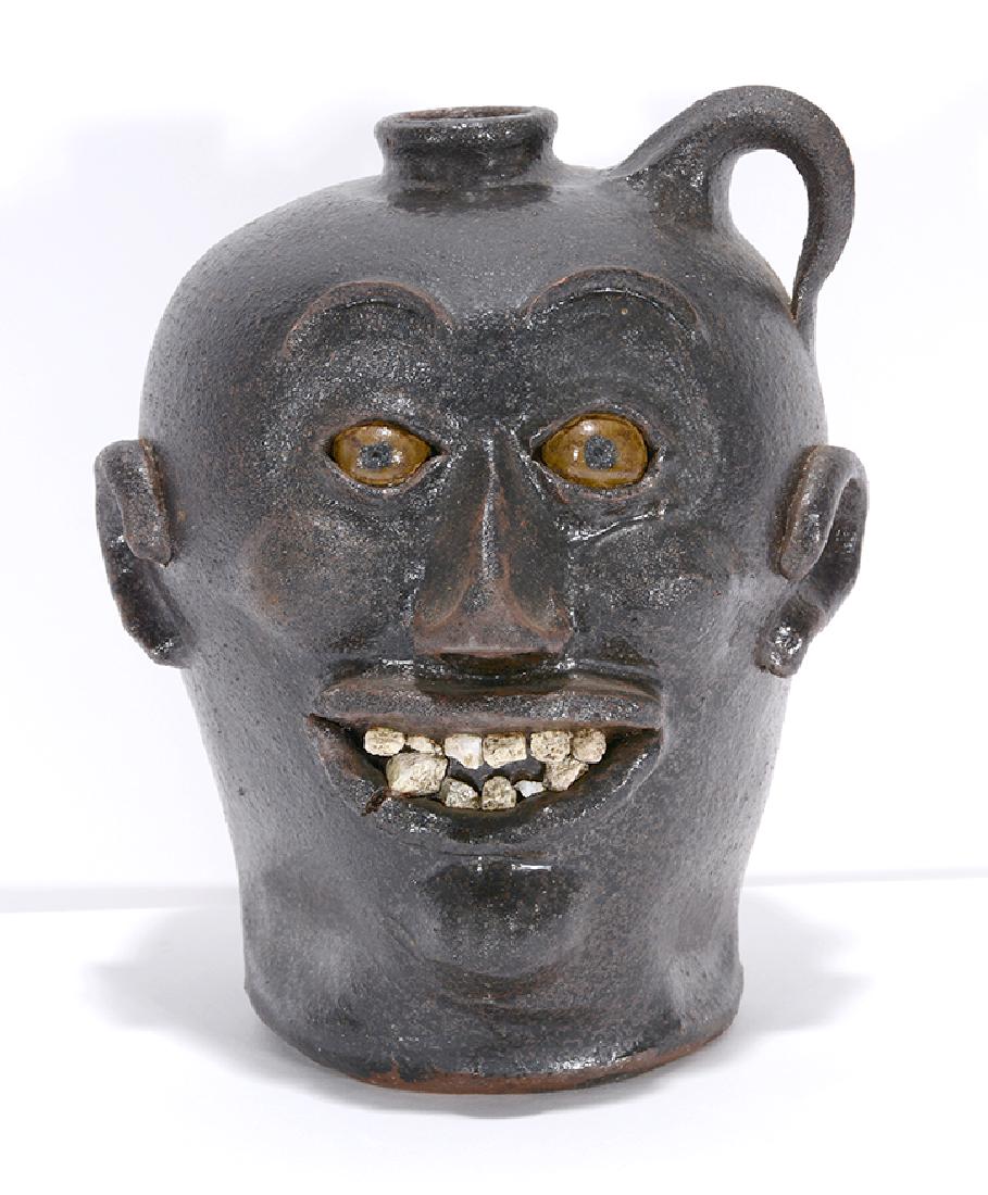 Charlie West. Rock Tooth Early Style Face Jug.: Charlie West. Rock Tooth Early Style Face Jug. 1995. Signed and dated. Rough matte glaze with quartz teeth. Mint condition. 9.5"h. Est. $300-500. Ship: $45