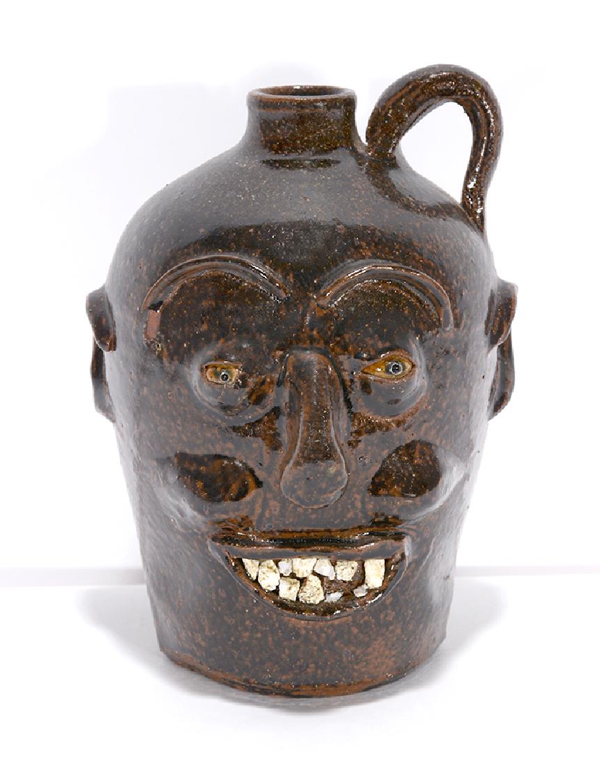 Charlie West. Spotted Early Face Jug.: Charlie West. Spotted Early Style Face Jug. Signed. Quartz teeth with spotted glaze. Minor loss to eyebrow and two teeth, otherwise good condition. 9.5"h. Est. $200-300. Ship: $45