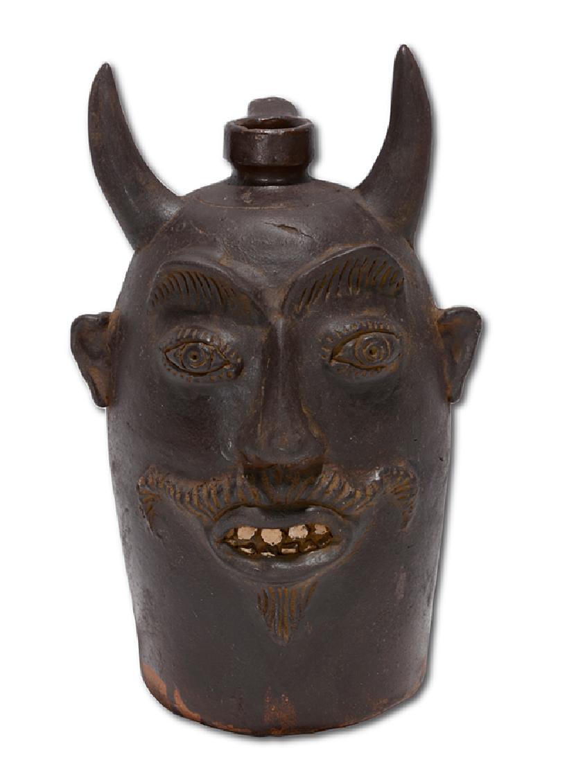 Contemporary KY. Sewer Tile Color Devil Face Jug.: Contemporary Kentucky Potter. Large Sewer Tile Color Devil Face Jug. c. Not signed. Glazed. China teeth. Minor chip, otherwise excellent condition. 11.5" h. Est. $1,000-2,000. Ship: $55