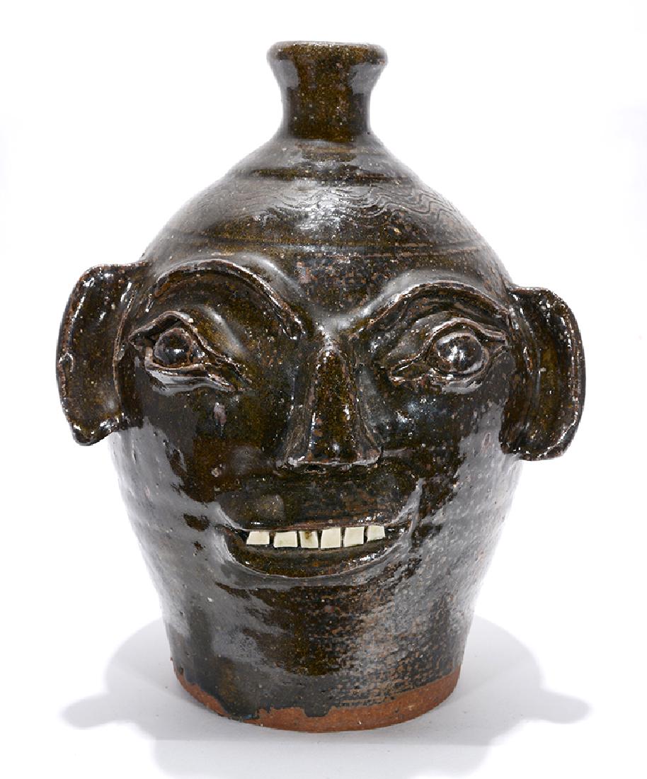 B.B. Craig. Two-Gallon Face Jug.: B.B. Craig. Two-Gallon Face Jug. Early example. Stamped. Albany-slip glaze, hand-dug clay with quartz. Mint condition. 12"h. Est. $800-1,200. Ship: $55