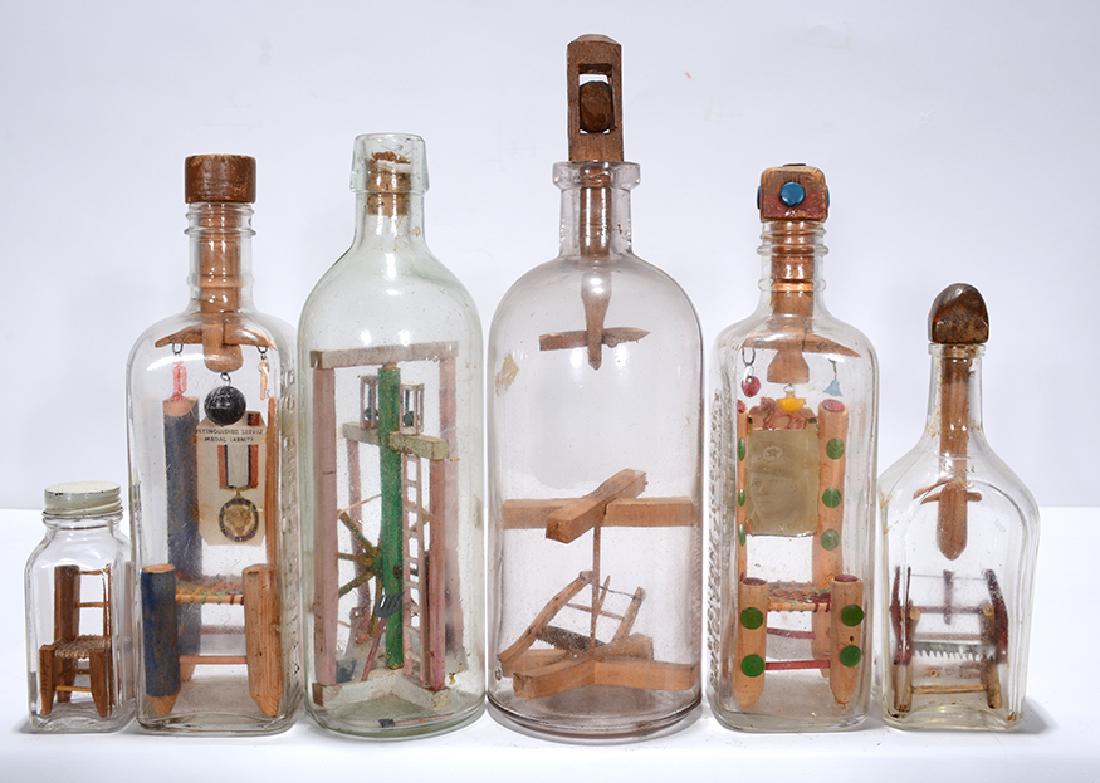 Six Bottles Whimseys With Chairs, Saws & Wheel.: ﻿Bottle Whimseys. Six Bottles With Chairs, Saws, Wheel. Not signed. The three Chairs In Bottles are from the same VA Hospital in Southern California, probably made by wounded military. Carved w