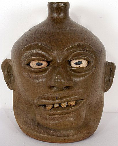 Lanier Meaders Rock Tooth Face Jug.: Rock Tooth Face Jug. Underfired matte glaze. c. early 1970's. Military green glaze. 10" h. Mint condition. Est. $2,000 - $3,000. Ship: $35