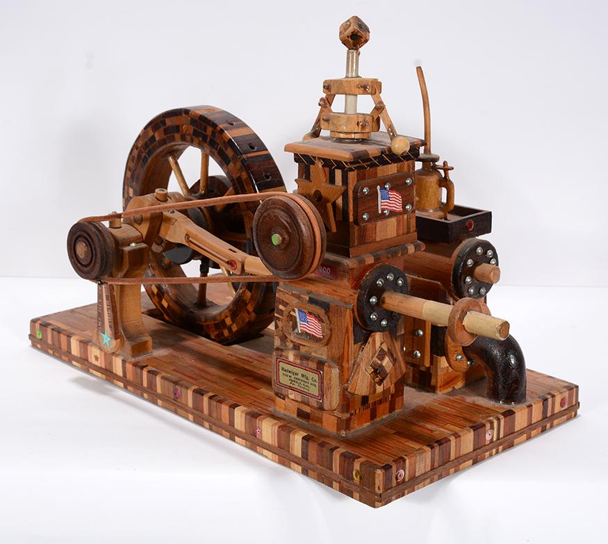 Oscar Hadwiger. 1st Steam Pump Pueblo Waterworks.: Oscar E. Hadwiger. 1st Steam Pump At Pueblo Waterworks. Original label with artist’s name and story of pump model. Carved variety of wood assembled by artist in his 80’s. Excellent conditi