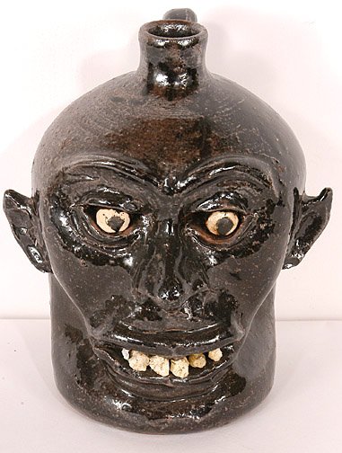 Lanier Meaders. Albany Slip Rock Tooth Face Jug: c. 1970's. 9.5" h. One quartz tooth is flaked during firing, otherwise mint condition. Est. $3,000 - $4,000. Ship: $40