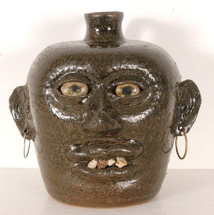 Lanier Meaders, Rock Tooth Face Jug.: Early piece from Personal Collection of Herbert Hemphill. Green Alkaline glaze. c. late 1960's. Signed on bottom. Metal earrings through holes in ear lobes. Glaze is scratched off small spot on right