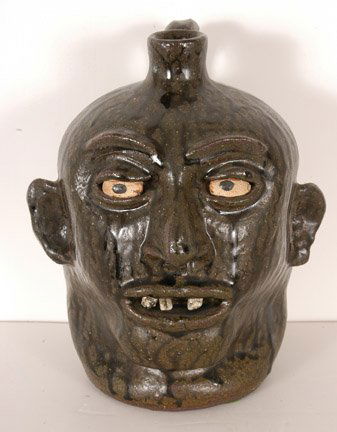 Lanier Meaders, Rock Tooth Face Jug.: c. late 1960's - early 1970's. 9.5"h. Great deep dark rich tobacco-spit glaze with fantastic drips. One tooth lost during firing, otherwise mint condition. Est. $2,000-3,000. Ship: $50