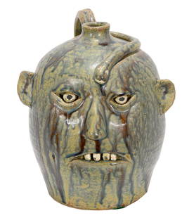 Reggie Meaders. Face Jug With Snake.: Reggie Meaders. (1919-2009)Face Jug With Snakes.Signed. Not dated.Nice experimental glaze.Mint condition.9” h.Est. $500-800. Ship: $45