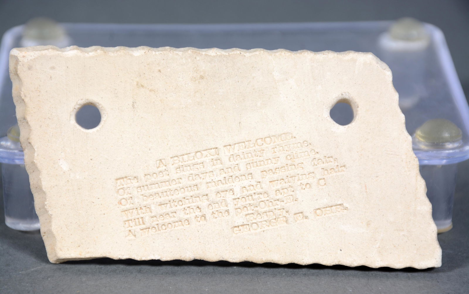 George Ohr. A Biloxi Welcome.: George Ohr. A Biloxi Welcome. Signed with stamped poem on tag-like ceramic. Mint condition. 3.5" x 2". Est. $300-500. Ship: $25