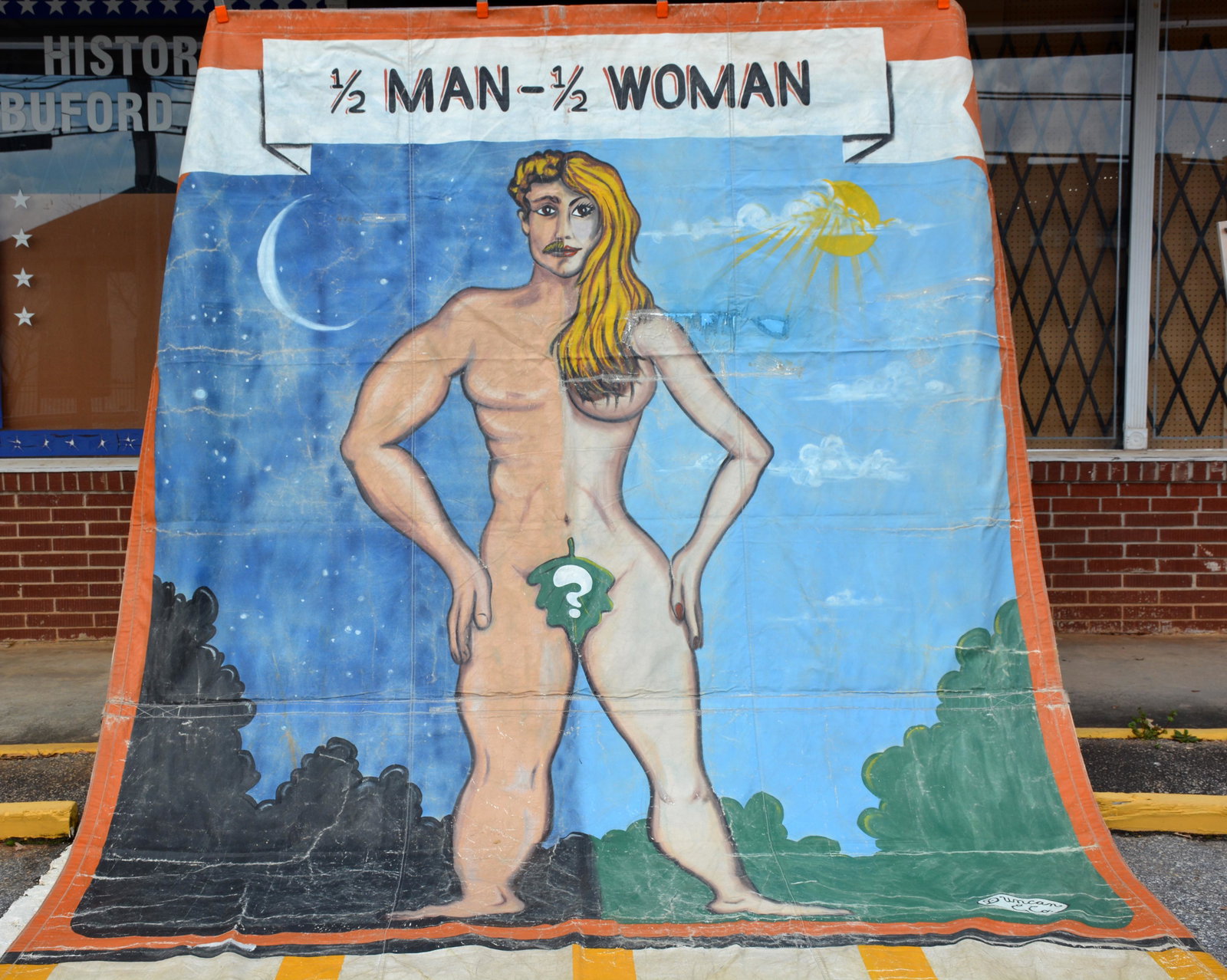 Duncan & Co. 1/2 Man - 1/2 Woman Circus Banner.: Duncan & Co. 1/2 Man - 1/2 Woman Circus Banner. c. 1960s. Signed and titled. Extra large side show banner. Paint on heavy canvas backed by vinyl. Expected wear, some repairs, overall great condition. 