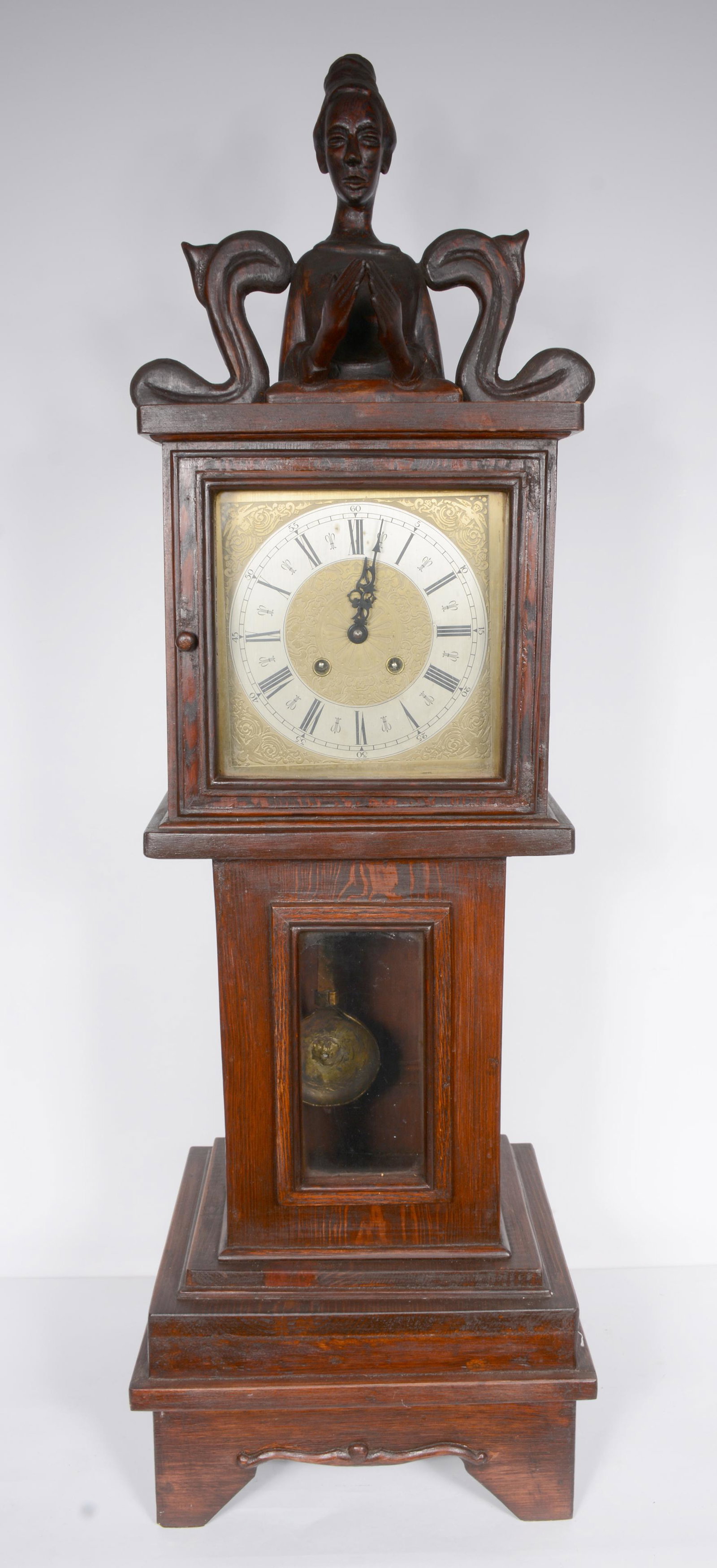 Rev. Joel D. Hewlett. Praying Grandma Clock Case.: Rev. Joel D. Hewlett. Praying Grandma Clock Case. Not signed. Carved woman on top of homemade clock case with clock and pendulum inside great condition. 41" h x 13" x 12". Est. $800-1,200. Buyer is re