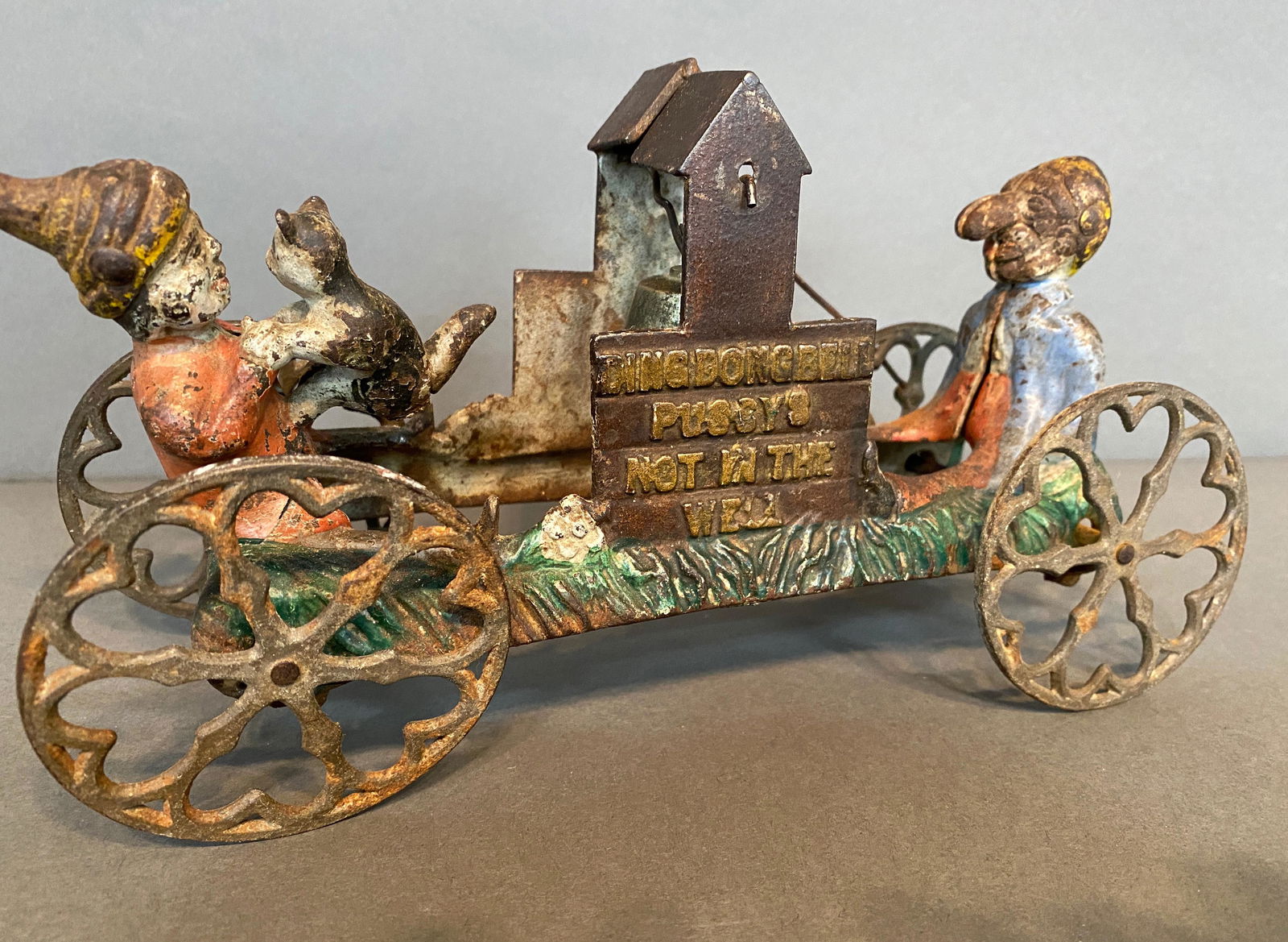 Ding Dong Bell Pussy's Not In The Well Toy.: Ding Dong Bell Pussy's Not In The Well Toy. c. 1900. Titled. Cast iron with some paint remnants. Child with cat broken off, otherwise fair condition. 5" h x 9" long x 3" w. Est. $200-300. Ship: $35 Di