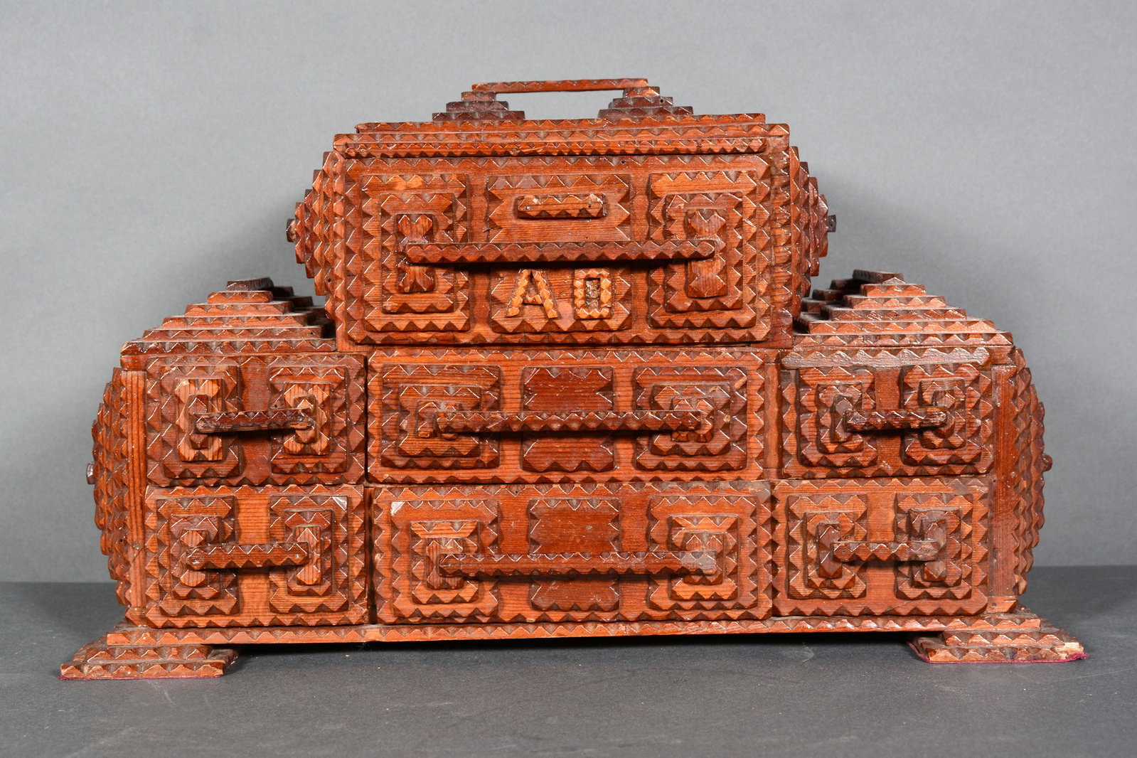 Initialed 'A.O.' Tramp Art Jewelry Box.: Initialed 'A.O.' Tramp Art Jewelry Box. c. 1900-1920s. 7 drawer box. Carved and stained wood. Excellent condition. 8.5" x 16" long x 7.5" d. Est. $300-500. Ship: $55